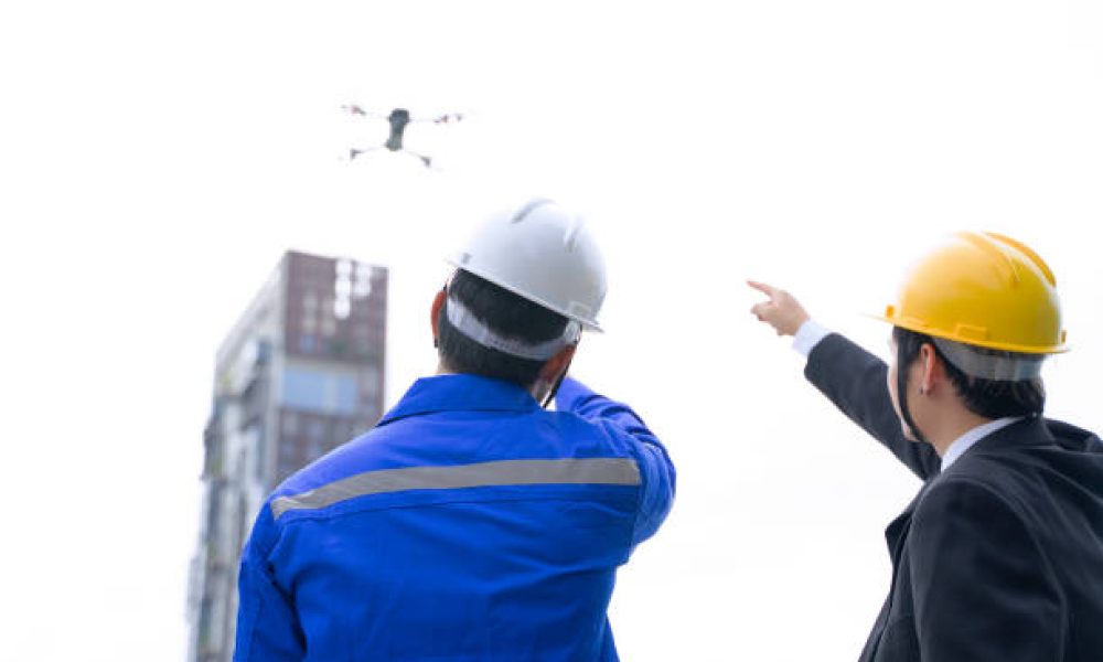 Engineer is working on the roof of building. Surrounding with high building. Construction, engineer and city concept.